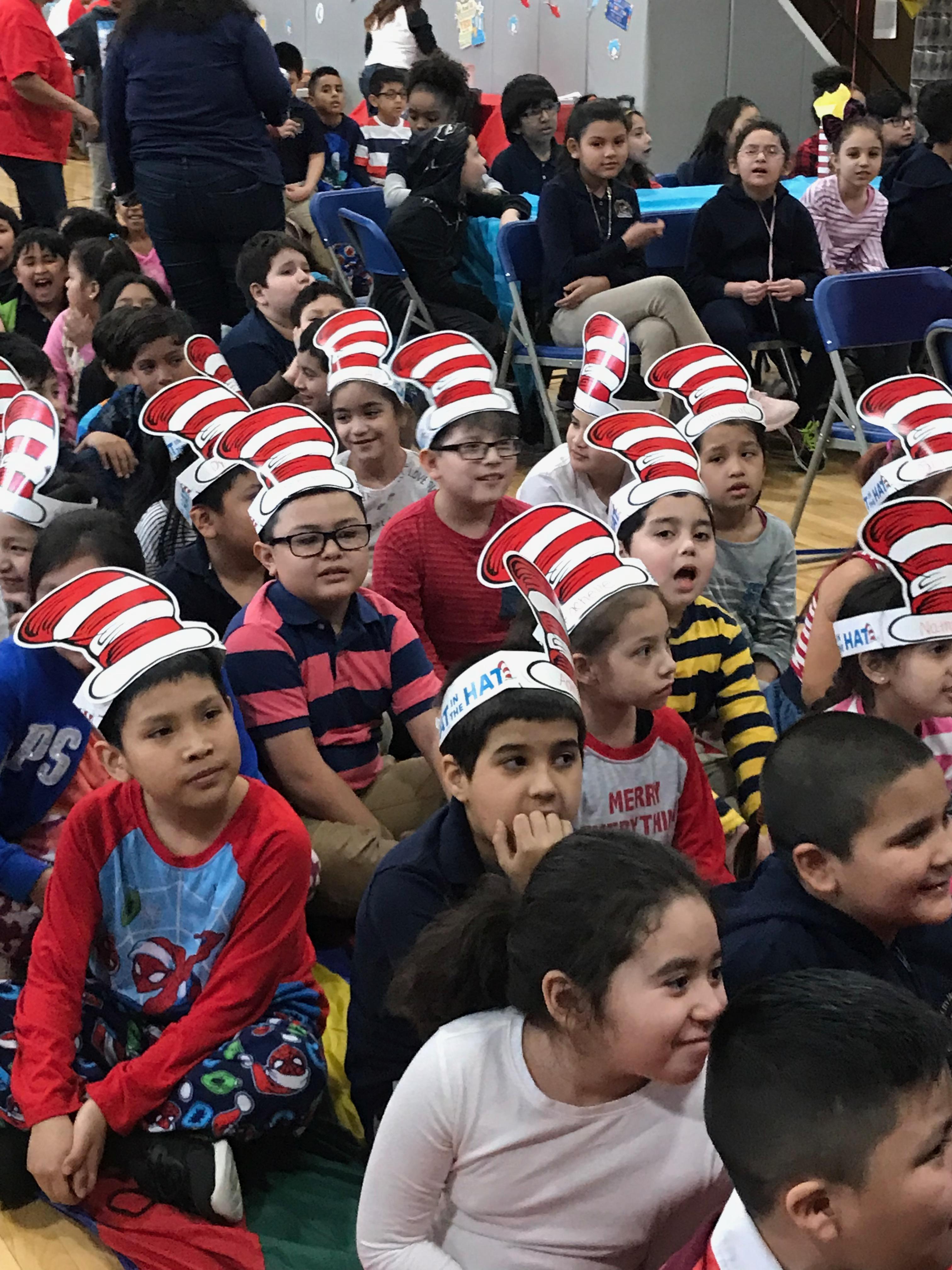 children sitting with their cat in the hat paper hats