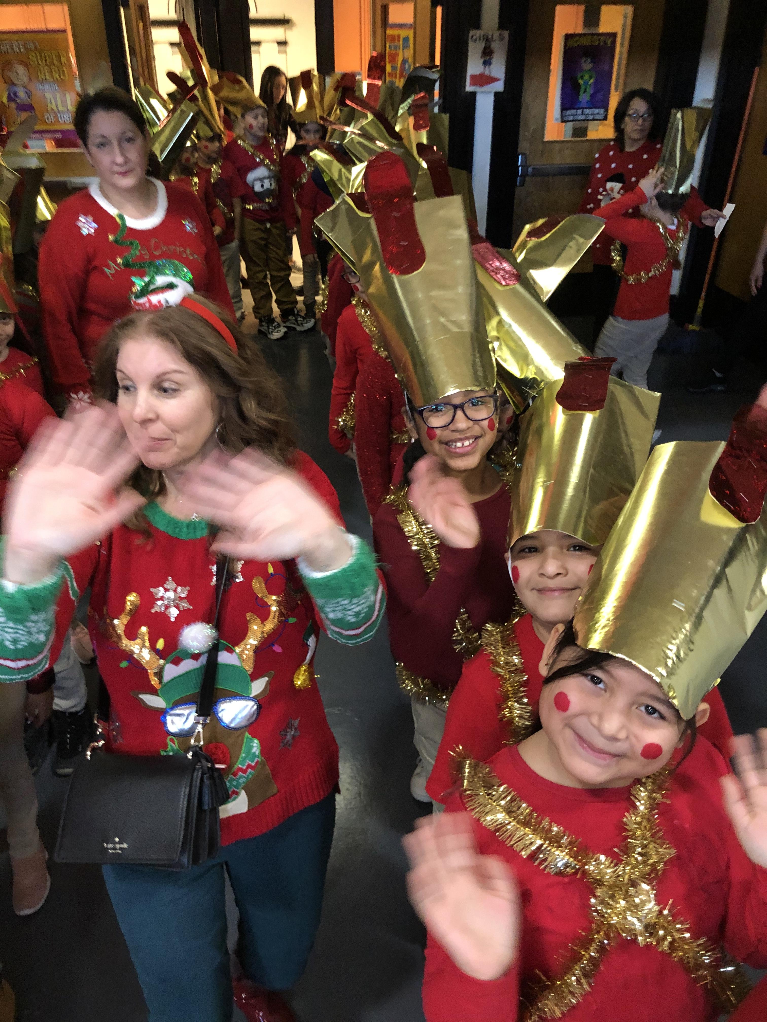 teachers with ugly sweaters and children dressed toy soldiers ready to perform
