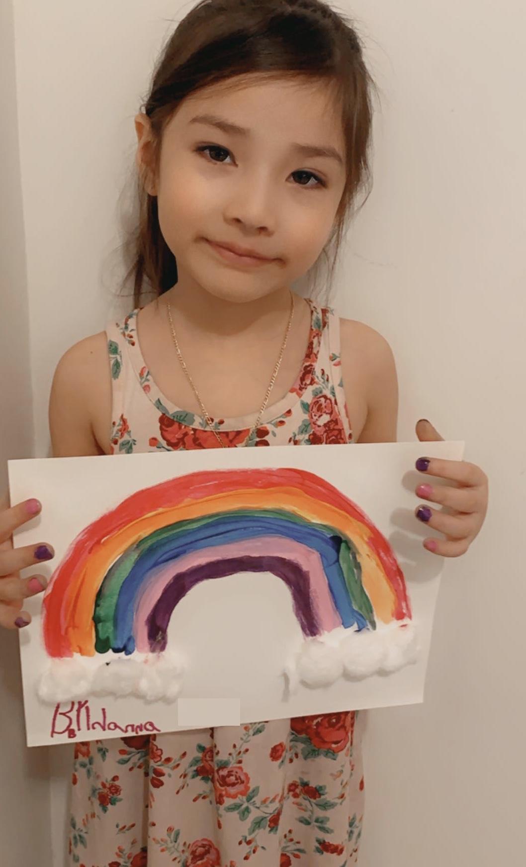 leann holding up her rainbow painting